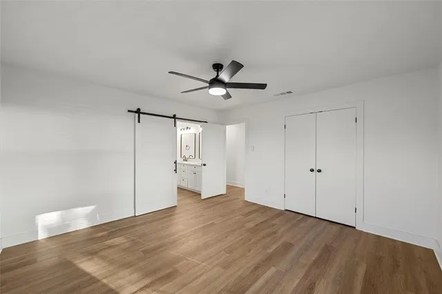 a view of empty room with wooden floor and ceiling fan