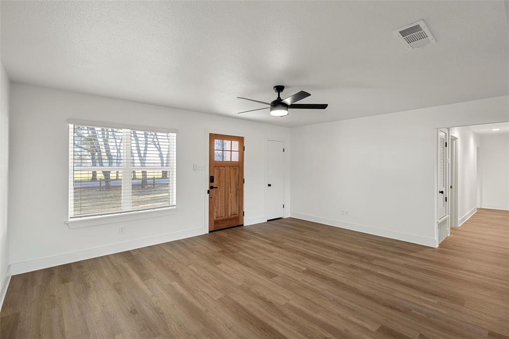 175 4 Corners Road West, TX 76691 - Photo 7 of 30 a view of an empty room with a window and wooden floor