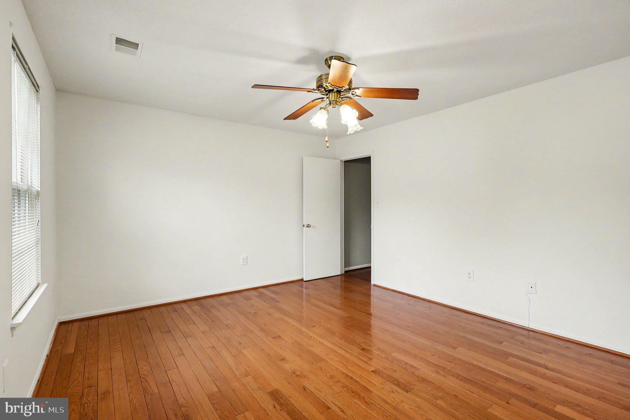 14721 McKnew Road Burtonsville, MD 20866 - Photo 12 of 30 a view of an empty room with wooden floor and a window