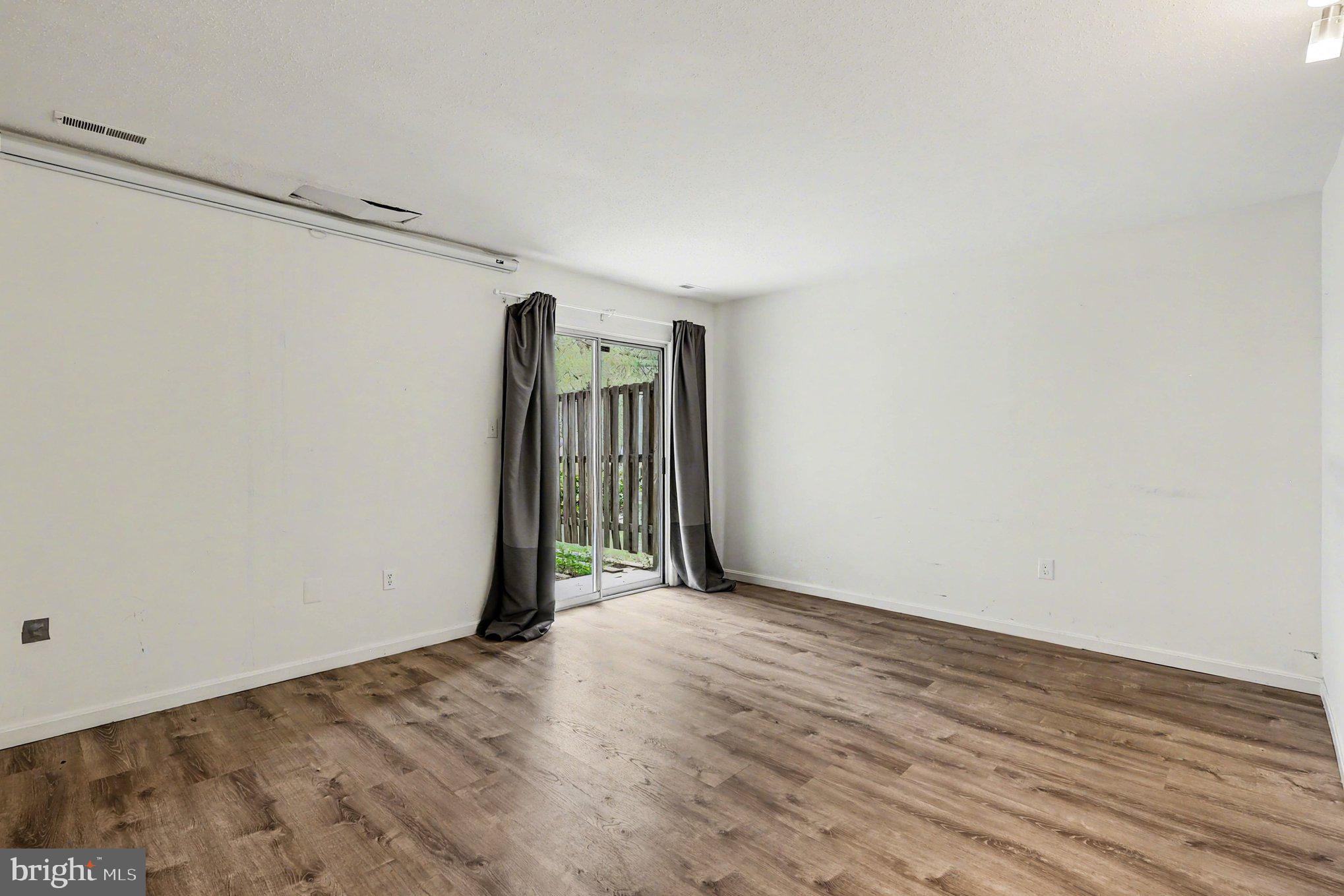14721 McKnew Road Burtonsville, MD 20866 - Photo 22 of 30 a view of an empty room with wooden floor