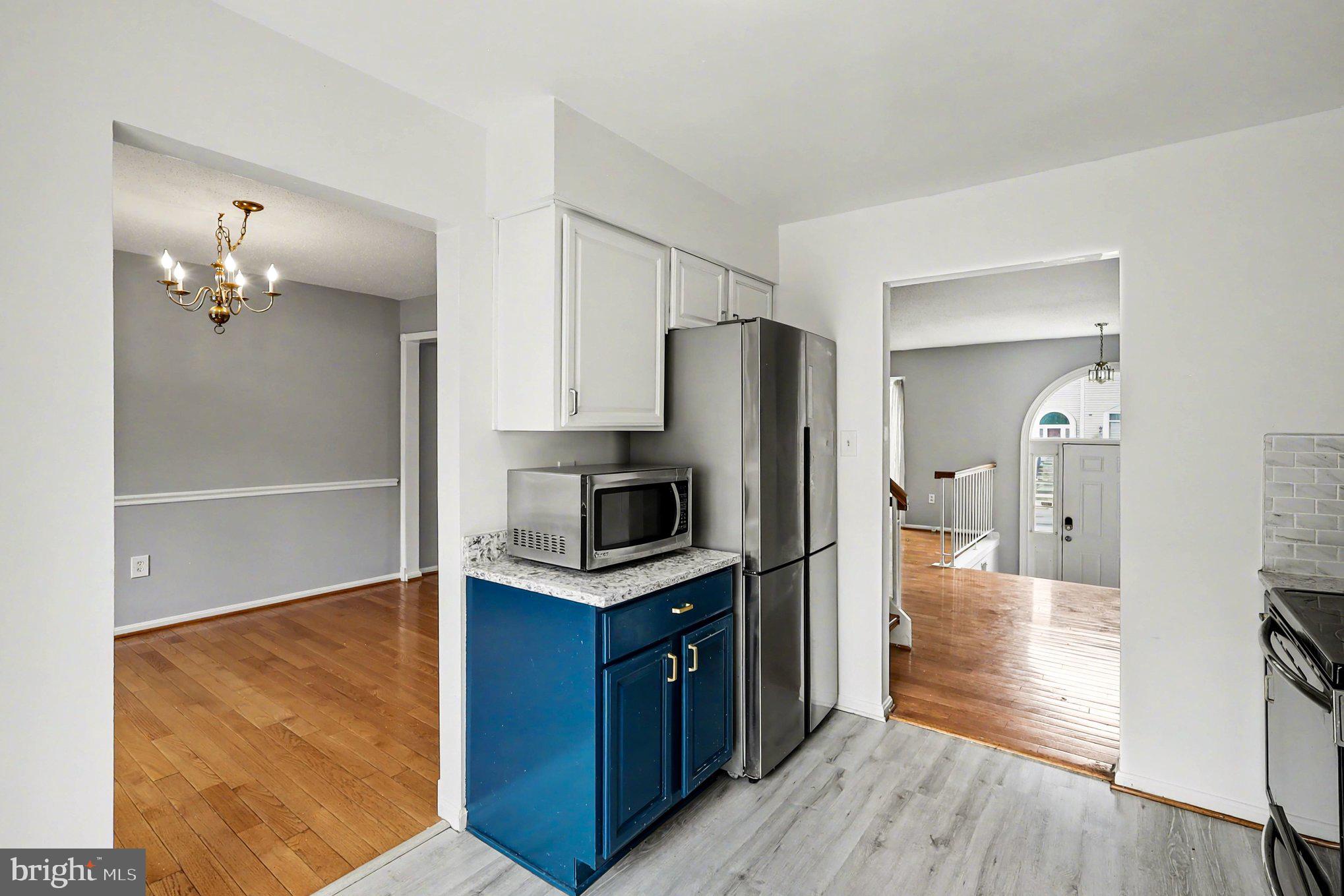 14721 McKnew Road Burtonsville, MD 20866 - Photo 7 of 30 a kitchen with kitchen island wooden floor appliances and cabinets