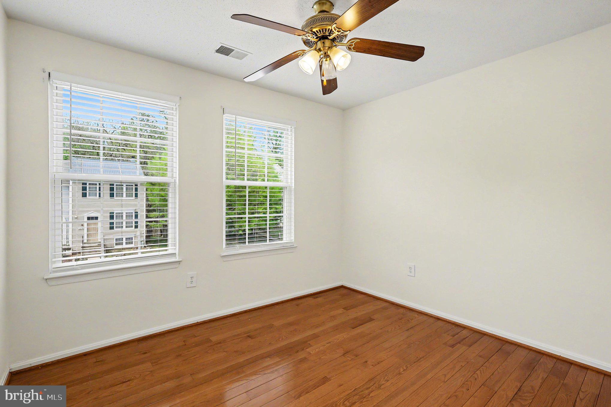 14721 McKnew Road Burtonsville, MD 20866 - Photo 10 of 30 an empty room with wooden floor fan and windows