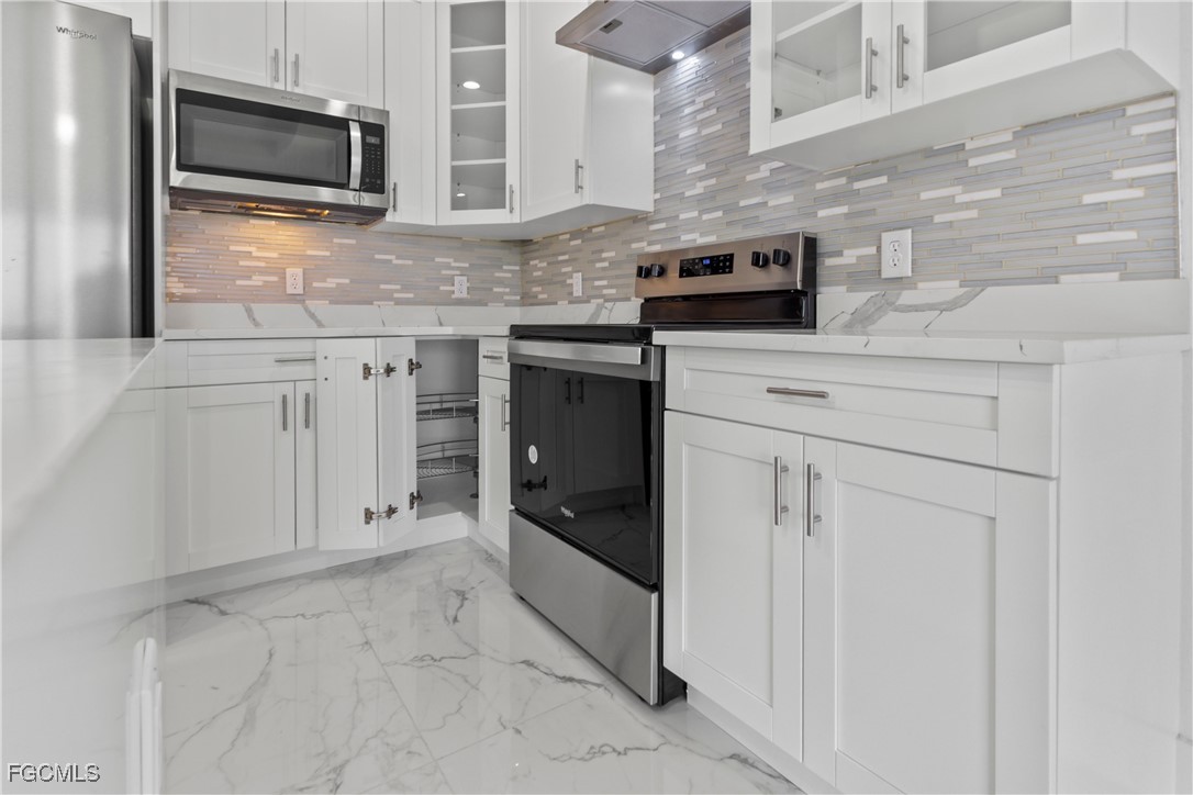7016 Tide Circle LaBelle, FL 33935 - Photo 15 of 47 a kitchen with stainless steel appliances granite countertop a stove and a microwave