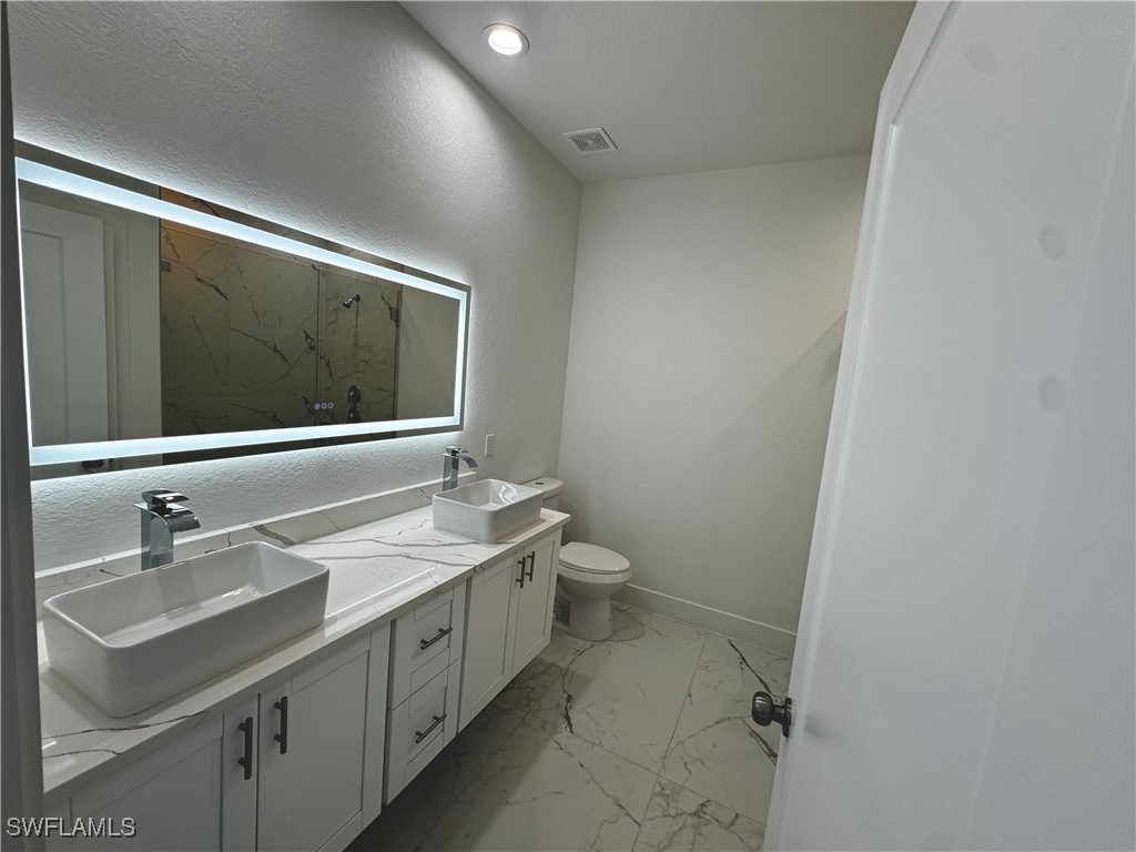 7016 Tide Circle LaBelle, FL 33935 - Photo 22 of 47 a bathroom with a double vanity sink and mirror