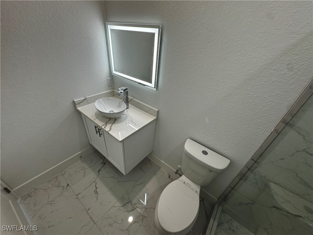 7016 Tide Circle LaBelle, FL 33935 - Photo 38 of 47 a bathroom with a granite countertop toilet sink and mirror