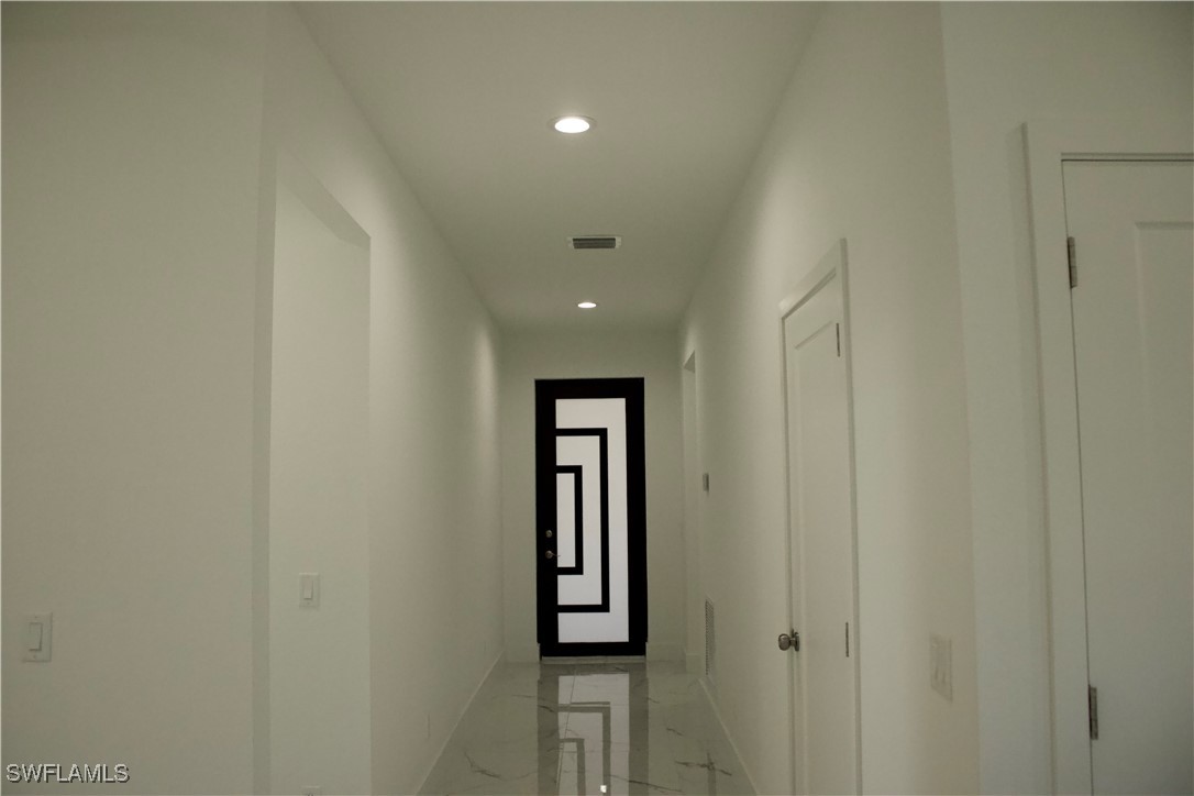 7016 Tide Circle LaBelle, FL 33935 - Photo 6 of 47 a view of a hallway with wooden floor and windows