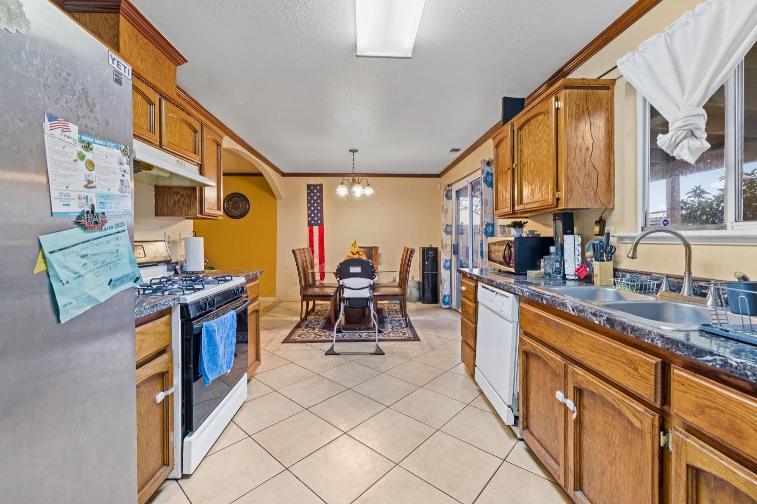 13590 9th Street Parlier, CA 93648 - Photo 12 of 30 a kitchen with stainless steel appliances granite countertop a stove a sink and a refrigerator
