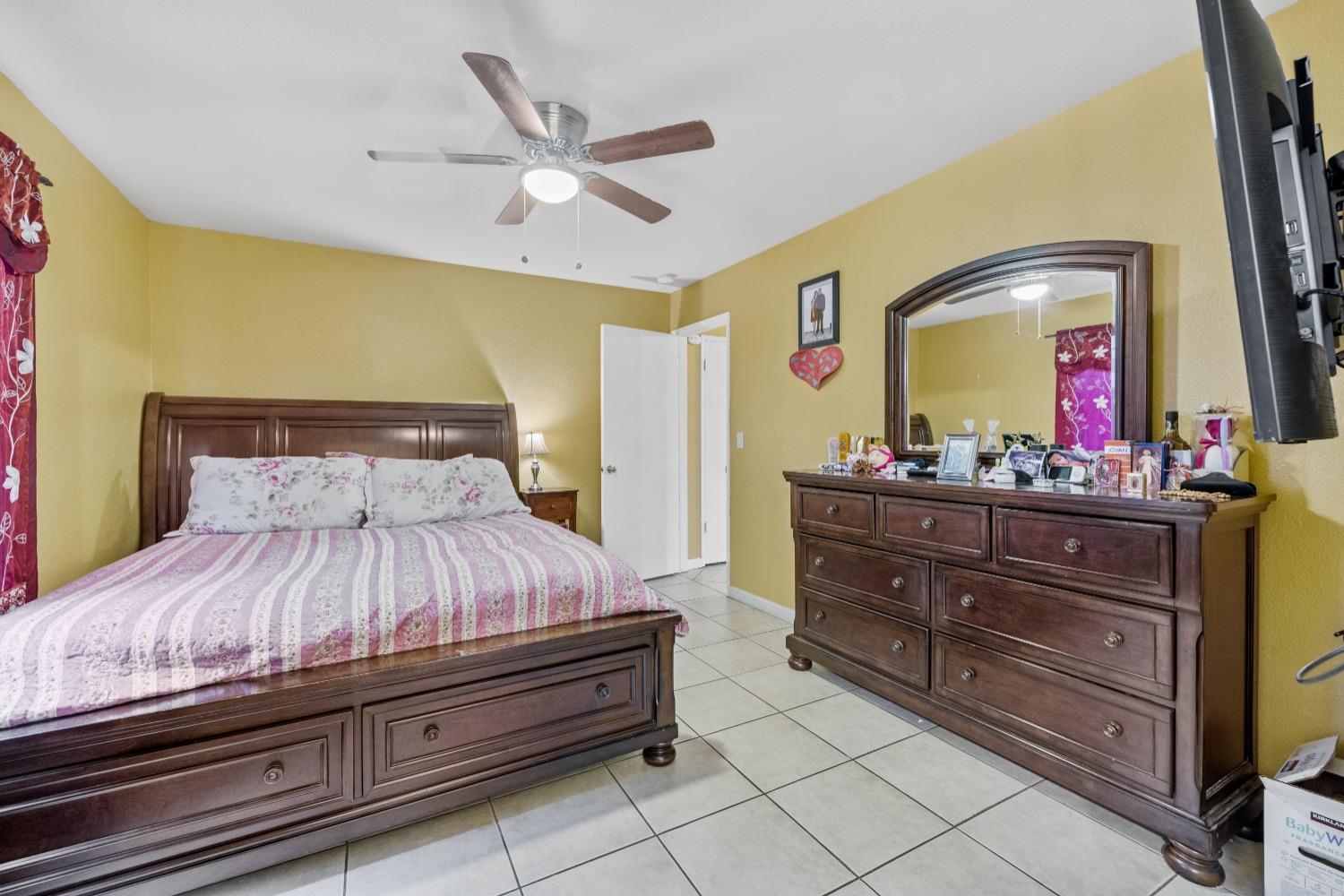 13590 9th Street Parlier, CA 93648 - Photo 15 of 30 a bedroom with a bed and a mirror on dresser