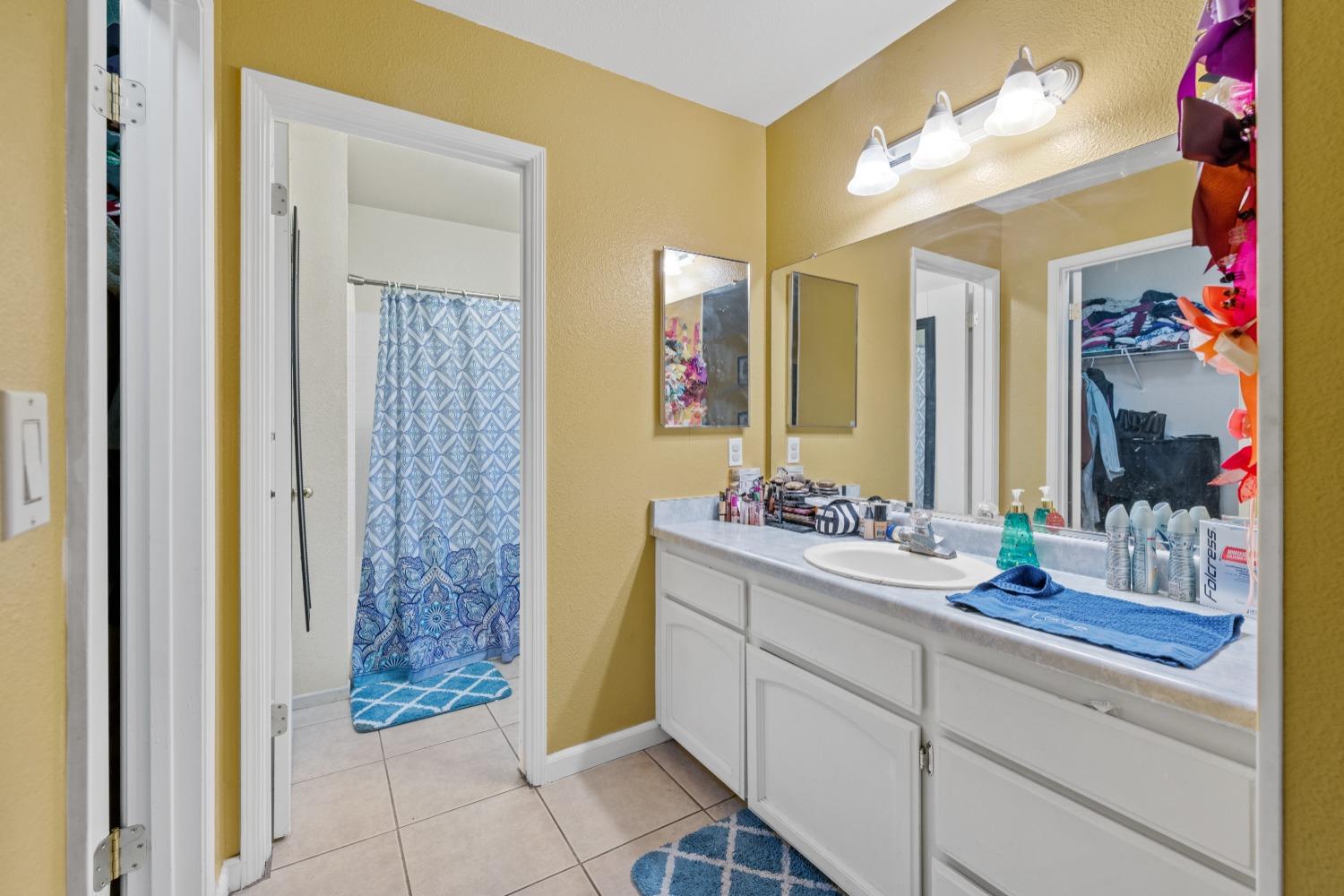 13590 9th Street Parlier, CA 93648 - Photo 16 of 30 a bathroom with a double vanity sink mirror and shower