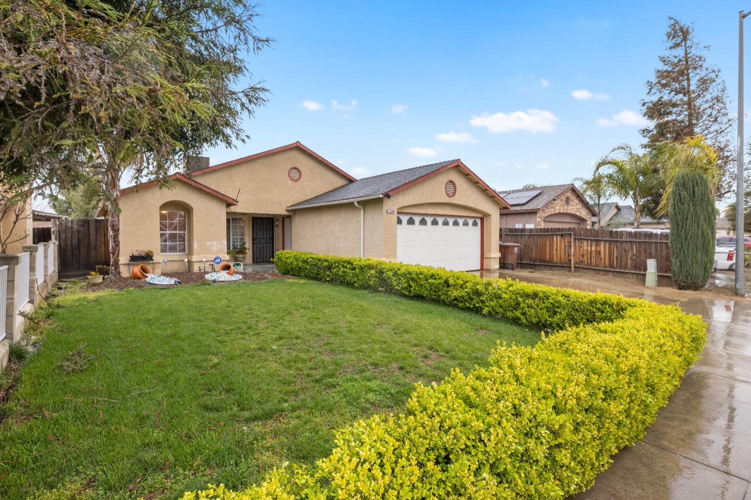 13590 9th Street Parlier, CA 93648 - Photo 2 of 30 a front view of a house with garden