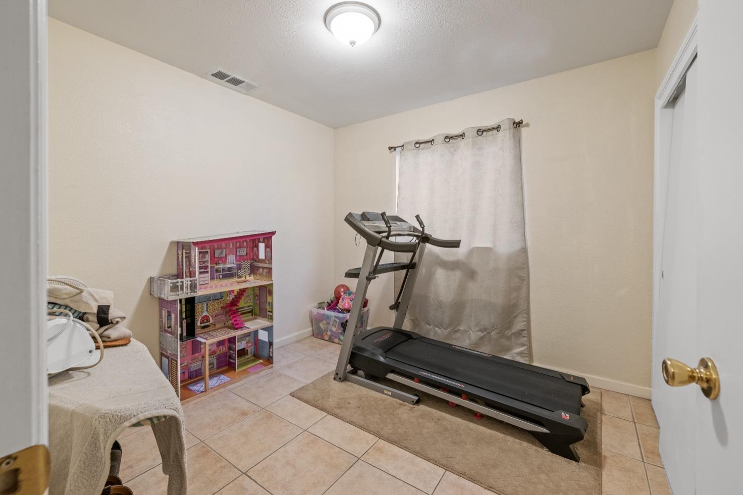 13590 9th Street Parlier, CA 93648 - Photo 24 of 30 a room with gym equipment and a mirror