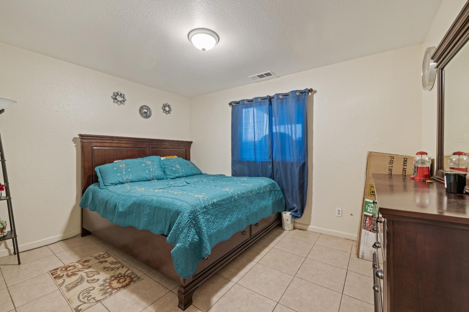 13590 9th Street Parlier, CA 93648 - Photo 25 of 30 a bedroom with a bed and cabinets