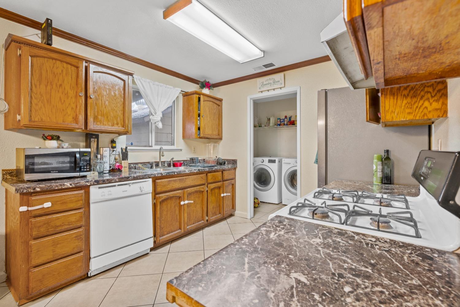 13590 9th Street Parlier, CA 93648 - Photo 9 of 30 a kitchen with a stove a sink and a refrigerator