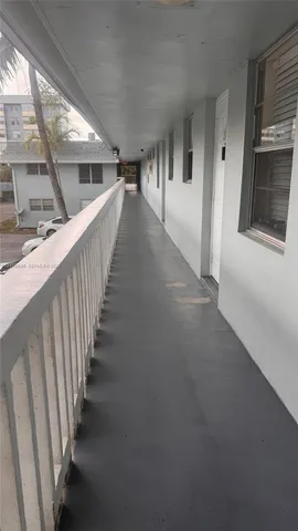 a view of a swimming pool with a lawn chairs and palm trees
