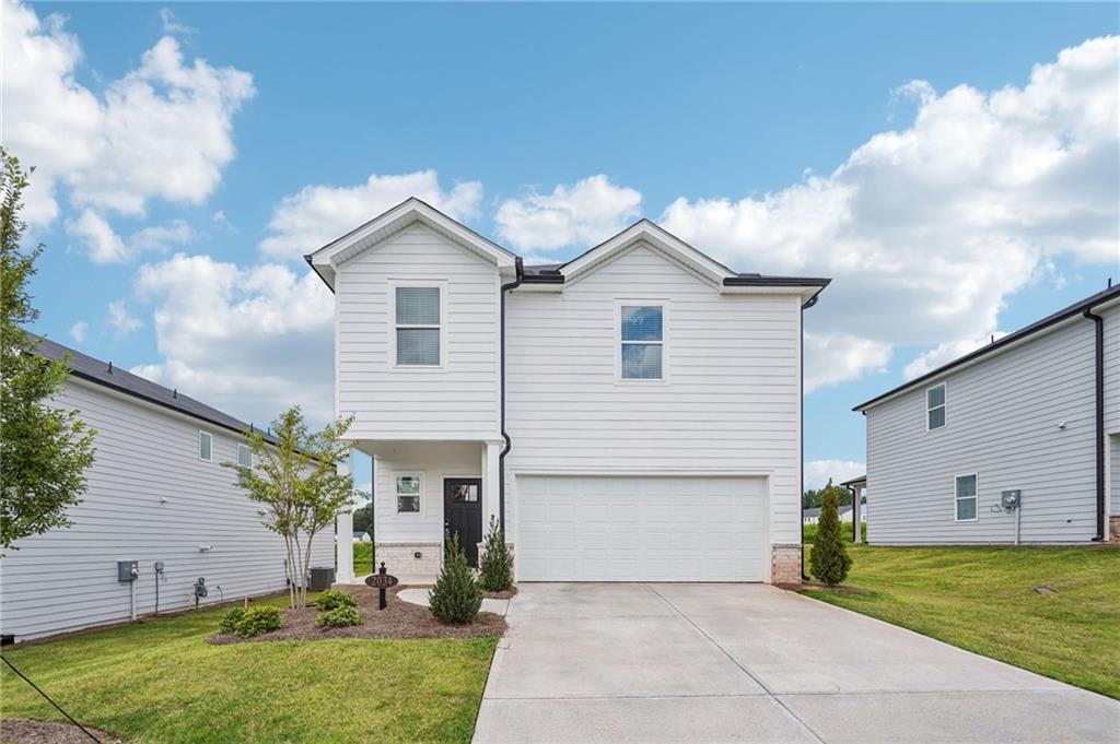 2034 Avalon Ridge Conyers, GA 30013 - Photo 1 of 35 a view of a house with a yard and a garage