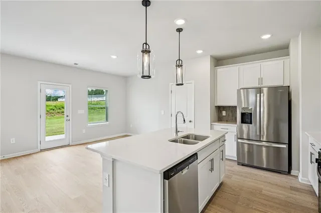 a kitchen with stainless steel appliances granite countertop a refrigerator a sink and a stove