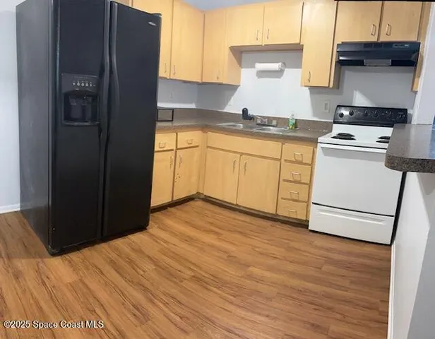 a kitchen with a stove cabinets and wooden floor
