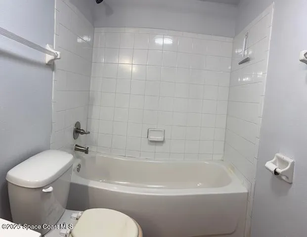 a white toilet sitting next to a bath tub