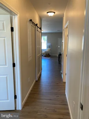 a view of a hallway with wooden floor