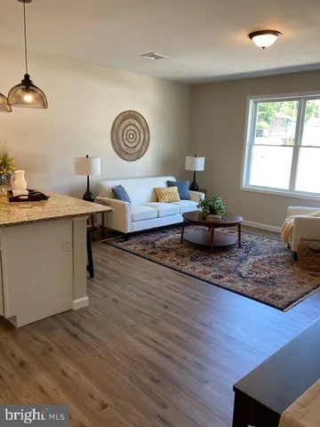 a living room with kitchen island furniture and wooden floor