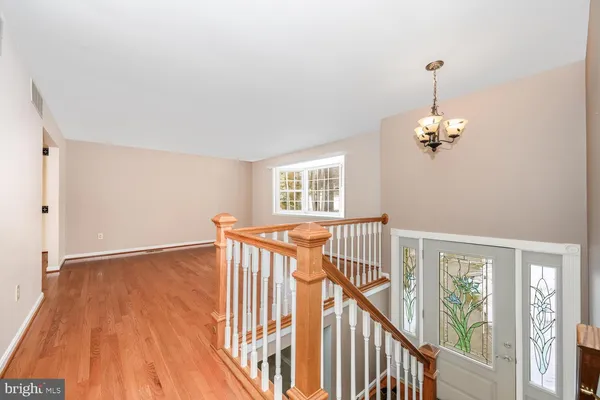 a view of a room with wooden floor windows and a chandelier