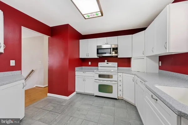 a kitchen with stainless steel appliances a stove microwave and sink