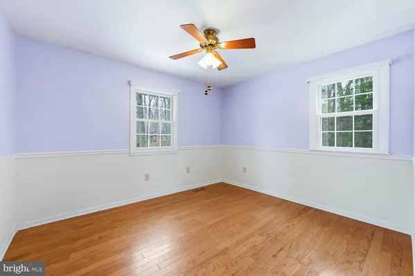 an empty room with a window and ceiling fan