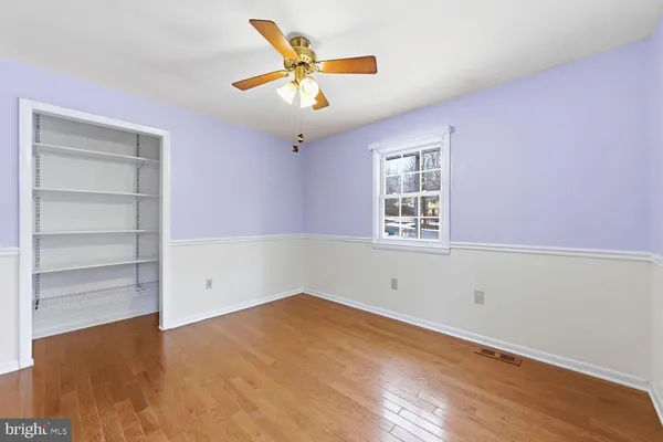 an empty room with a window and a ceiling fan