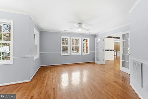 an empty room with wooden floor and windows