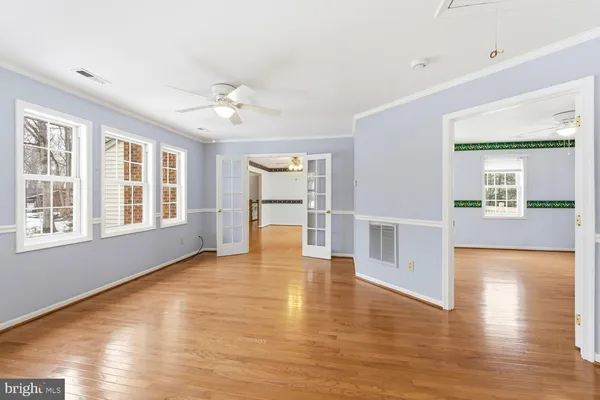 a view of an empty room with window and wooden floor