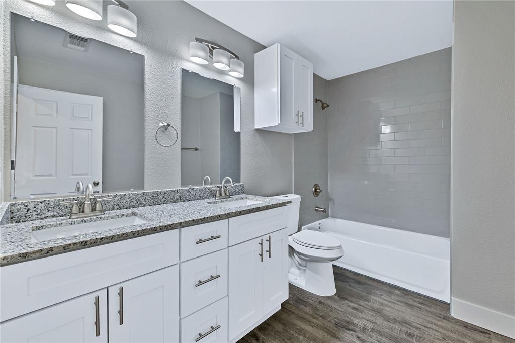 566 McCraw Lane Denison, TX 75021 - Photo 14 of 25 a bathroom with a granite countertop sink a toilet and a mirror