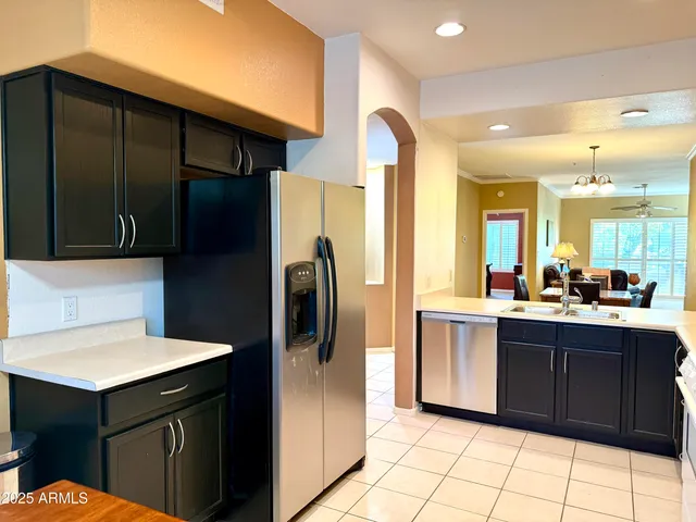 a kitchen with a sink a refrigerator and cabinets