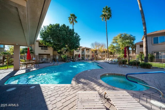 a view of a patio with table and chairs potted plants and a palm tree