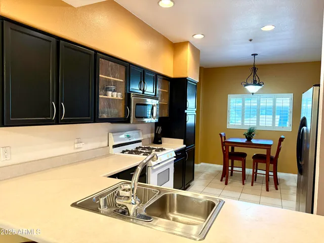 a kitchen with stainless steel appliances kitchen island granite countertop a sink and cabinets