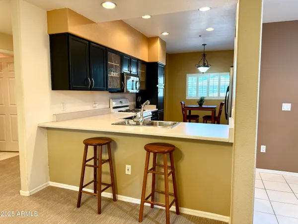 a kitchen with a sink a counter and chairs