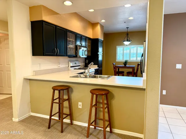 a kitchen with a sink a counter and chairs