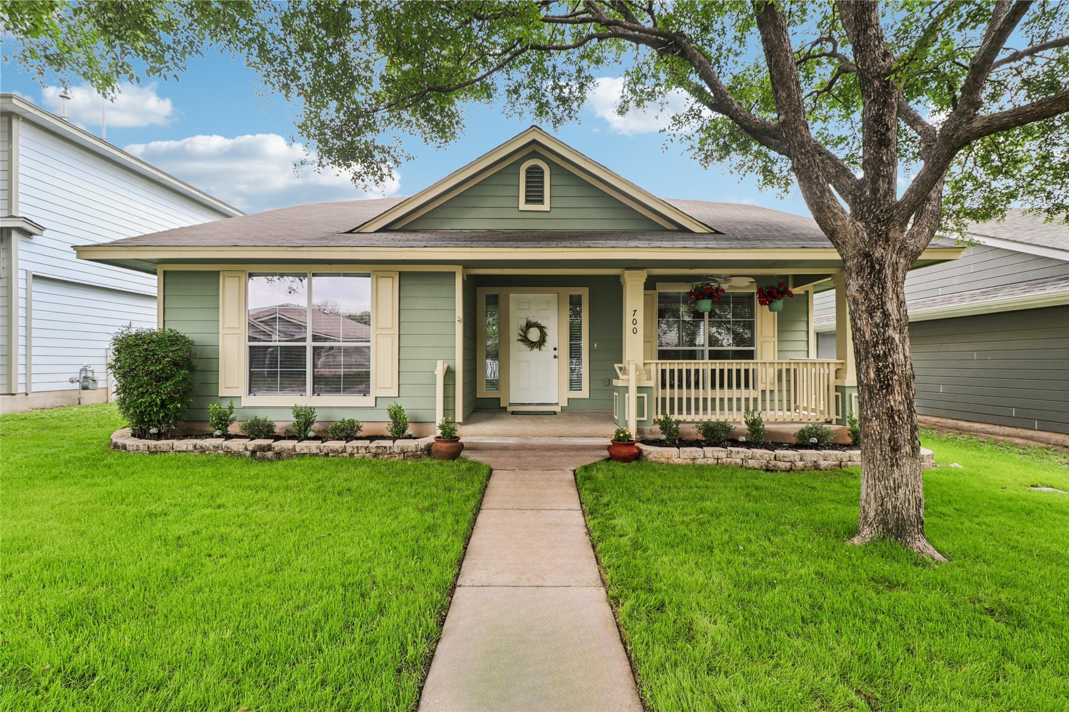 700 Scheel Road Kyle, TX 78640 - Photo 1 of 1 The property features a well-maintained lawn, a mature tree, and a concrete pathway leading to the front entrance