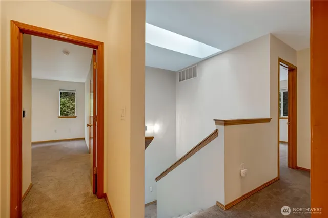a view of a hallway with closet and mirror