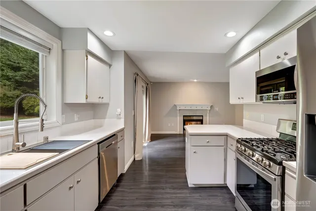 a kitchen with granite countertop a sink stove and cabinets