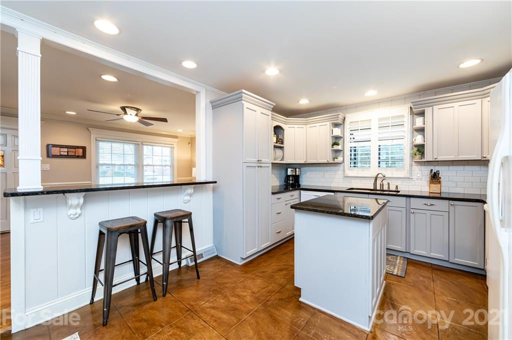 1417 Burnley Road Charlotte, NC 28210 - Photo 16 of 43 a kitchen with stainless steel appliances granite countertop sink stove top oven and cabinets