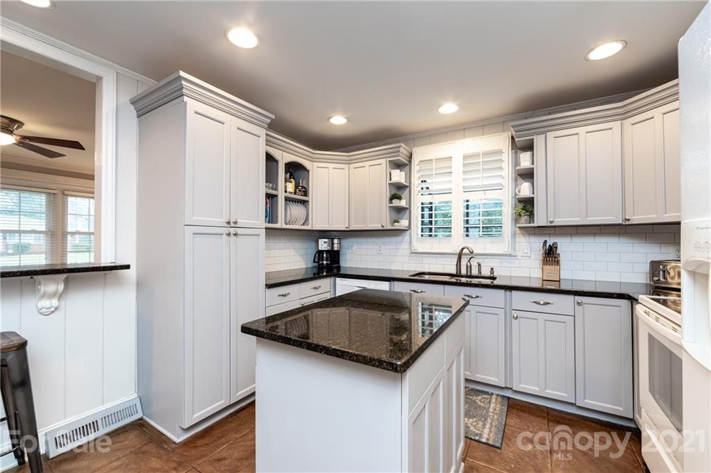 1417 Burnley Road Charlotte, NC 28210 - Photo 17 of 43 a kitchen with kitchen island granite countertop a sink stainless steel appliances and cabinets