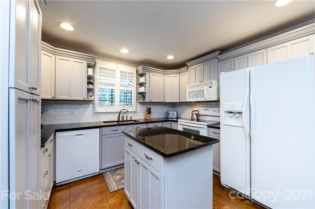 1417 Burnley Road Charlotte, NC 28210 - Photo 18 of 43 a kitchen with a sink a stove a refrigerator and cabinets