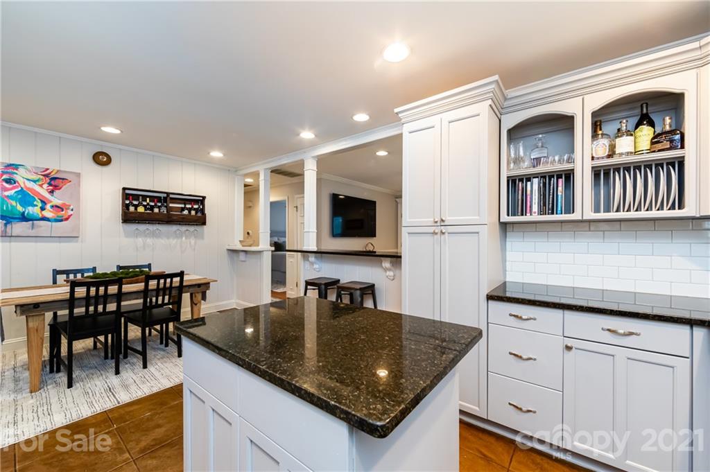 1417 Burnley Road Charlotte, NC 28210 - Photo 21 of 43 a kitchen with stainless steel appliances granite countertop a stove a sink a dining table and chairs with wooden floor