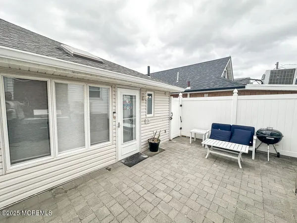 a backyard of a house with barbeque oven table and chairs