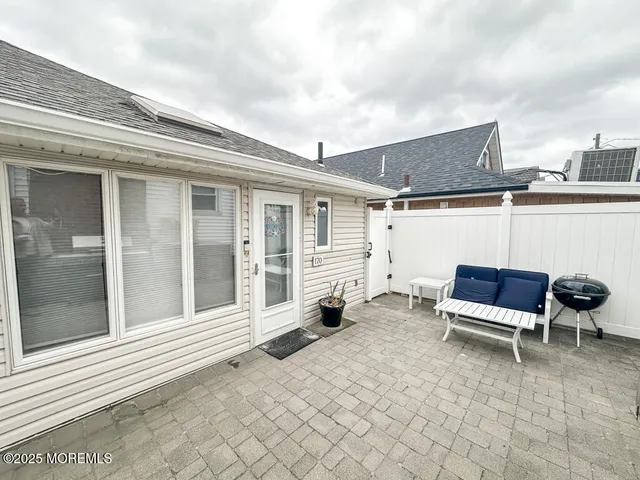 a backyard of a house with barbeque oven table and chairs