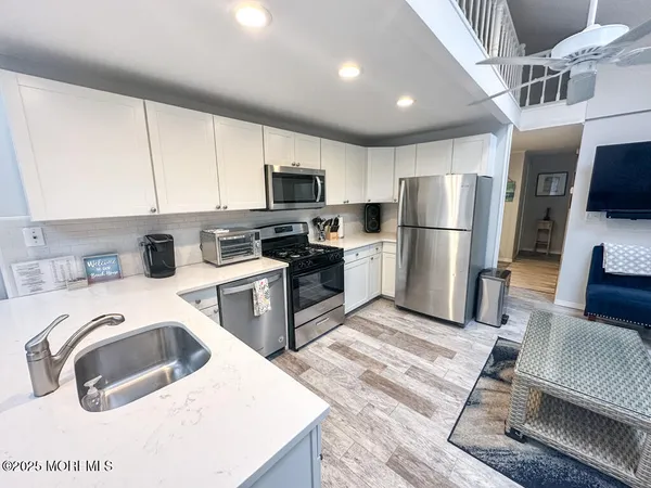 a kitchen with a refrigerator a stove top oven a sink and cabinets