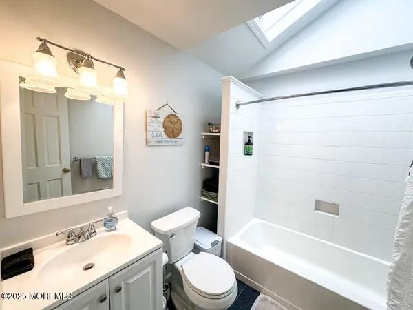 a bathroom with a sink toilet vanity and shower