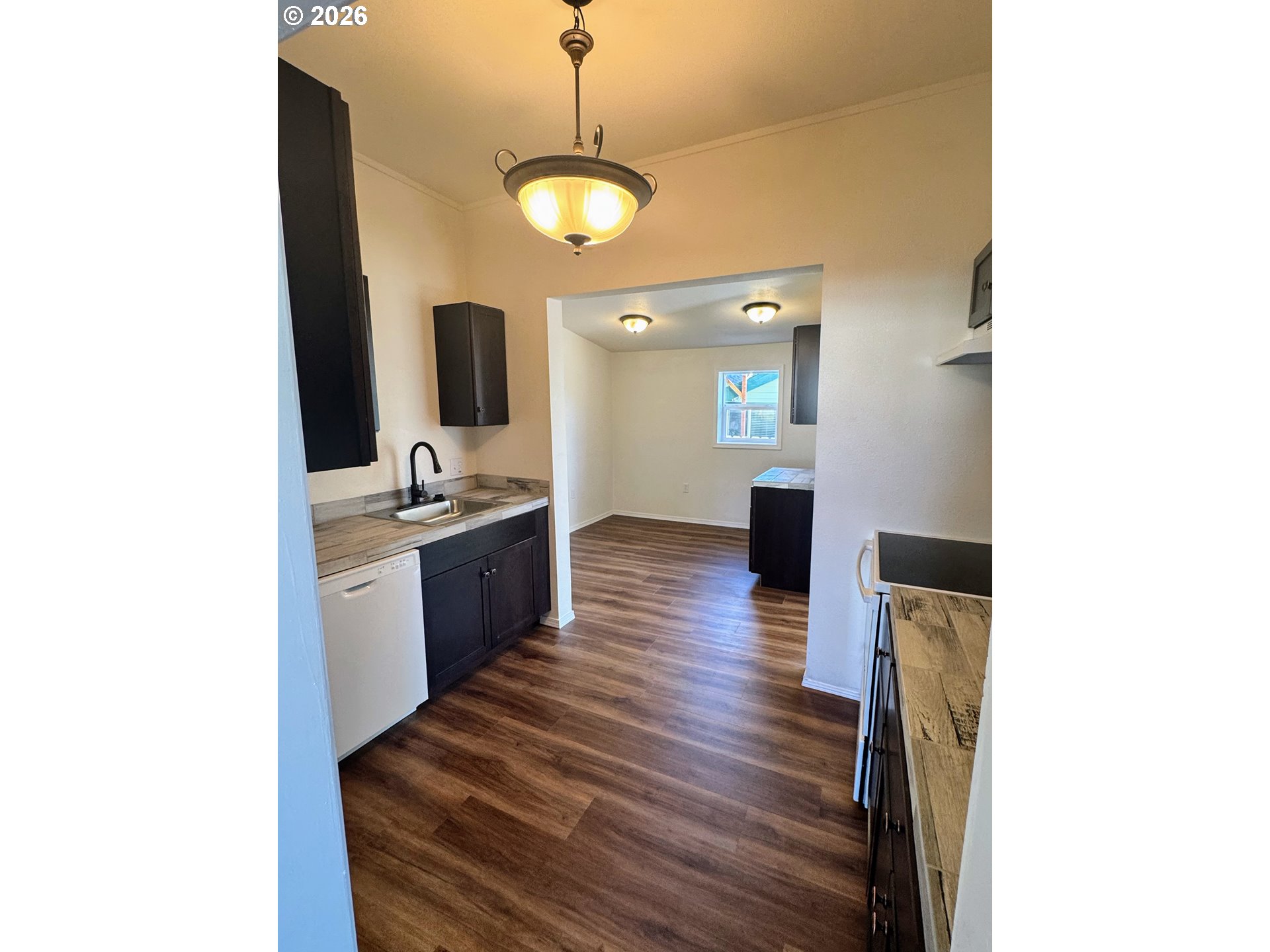 584 North Baxter Street Coquille, OR 97423 - Photo 24 of 39 a large kitchen with a sink and dishwasher a stove with wooden floor