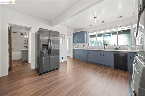 a kitchen with stainless steel appliances granite countertop a refrigerator and a sink