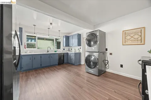 a view of a kitchen with fridge and wooden floor